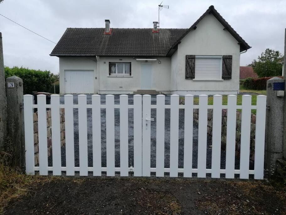 une clôture blanche devant une maison blanche dans l'établissement Charmant pavillon des années 70, à Sommervieu
