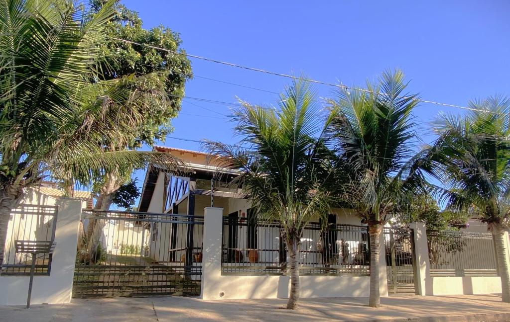 una casa con palmeras delante en Casa próxima a Praça Central en Chapada dos Guimarães