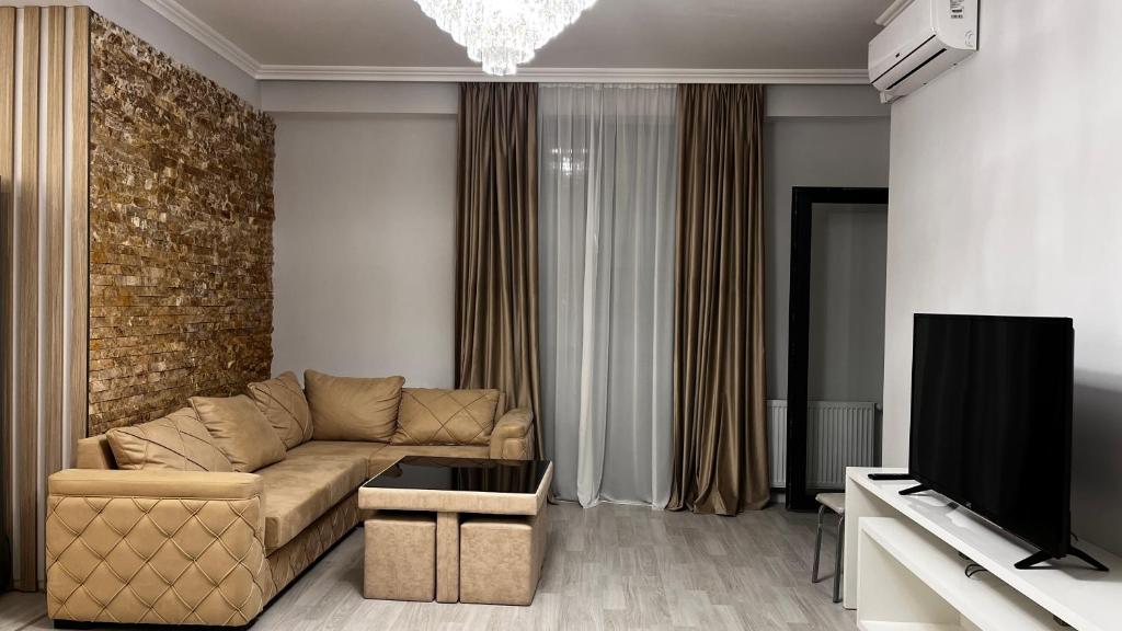 a living room with a couch and a tv at Apartment in Tbilisi City