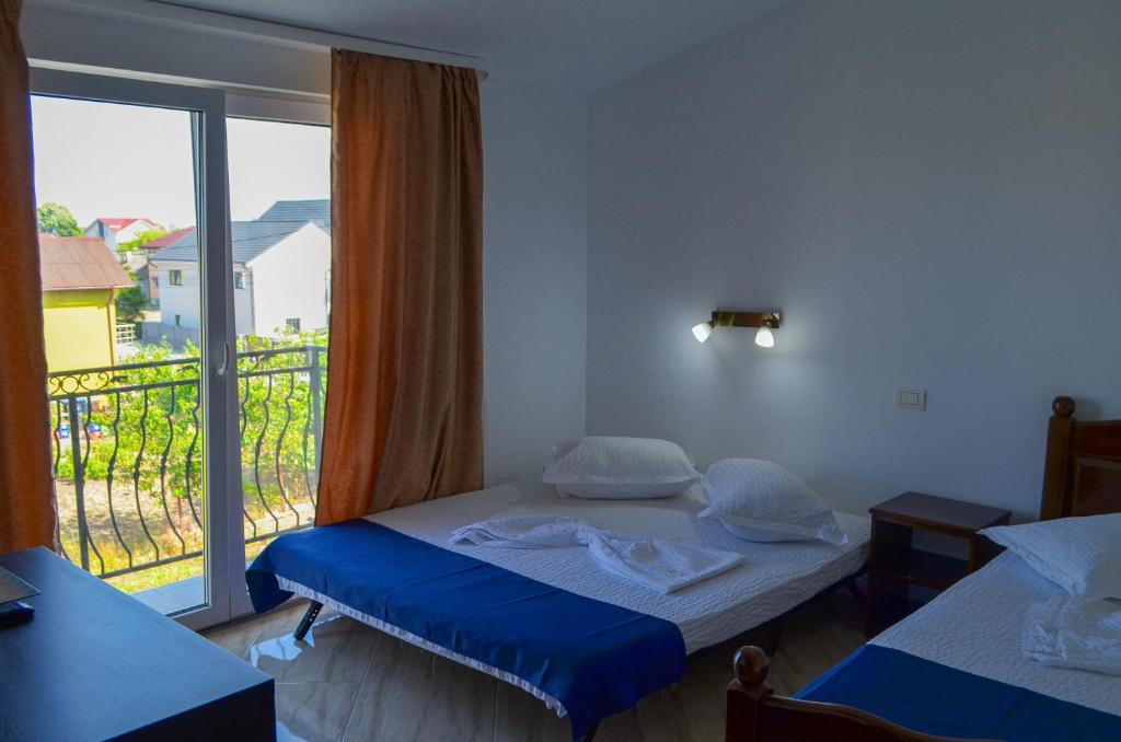 a bedroom with a bed and a large window at Roman Costinesti in Costinesti