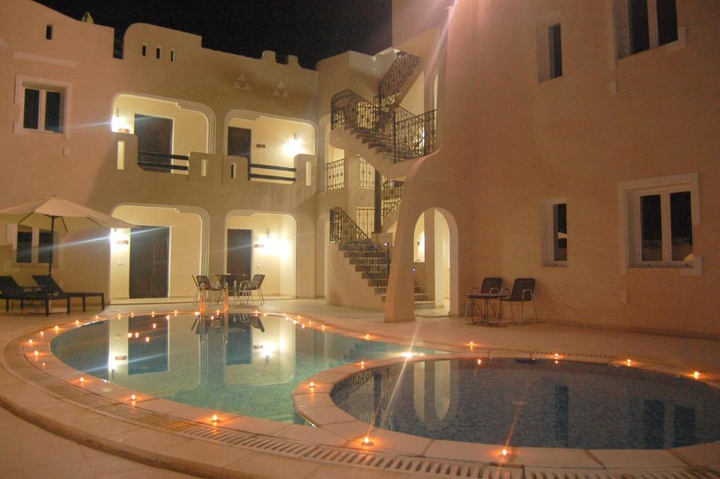 a swimming pool in front of a house at night at Résidence Chahd de Charme in Mezraya