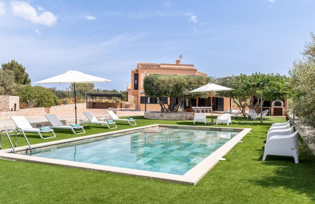 een zwembad met stoelen en parasols en een huis bij Villa Can Bellmunt in La Aranjasa