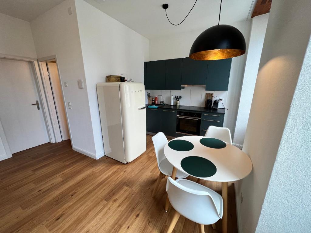 a kitchen with a table and a white refrigerator at Stay Swiss 1 bedroom apartments in old town in Porrentruy