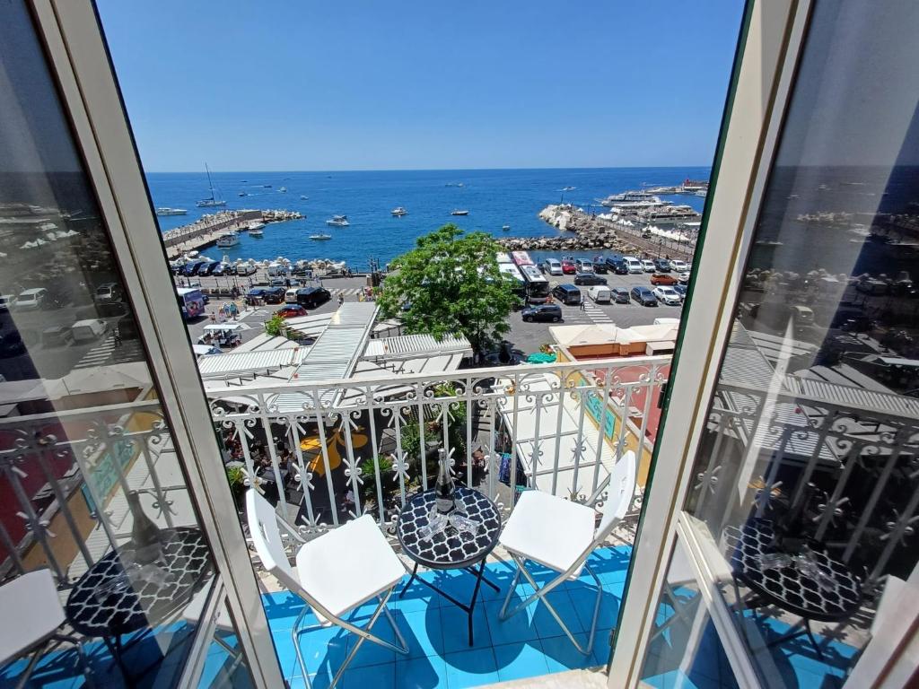 een balkon met stoelen en uitzicht op de oceaan bij Love and Passion Amalfi in Amalfi