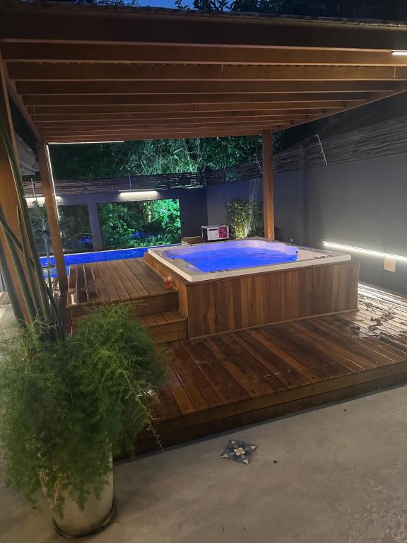 咎凱的住宿－Casa térrea com acessibilidade em Juquehy com piscina aquecida e hidromassagem，木制甲板上的大型游泳池