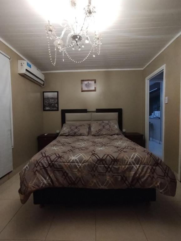 1 dormitorio con cama y lámpara de araña en Finca y temporarios la BENDECIDA en Santiago del Estero