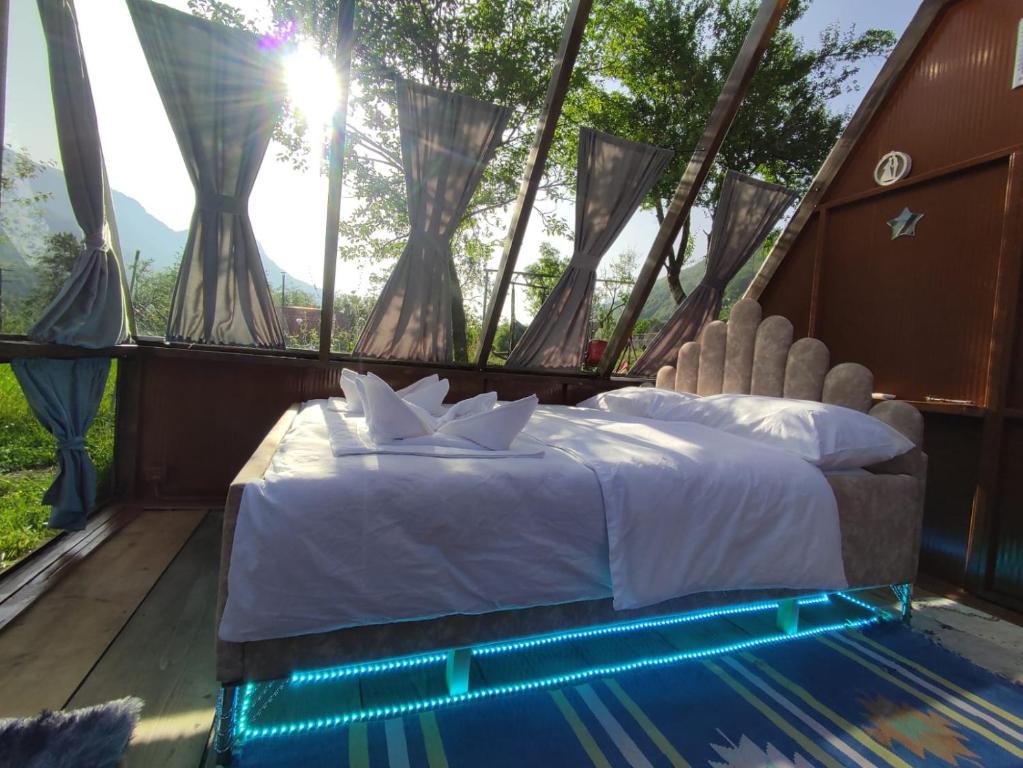 een slaapkamer met een bed in een tent met een raam bij UNDER STARS HOUSE in Vermosh