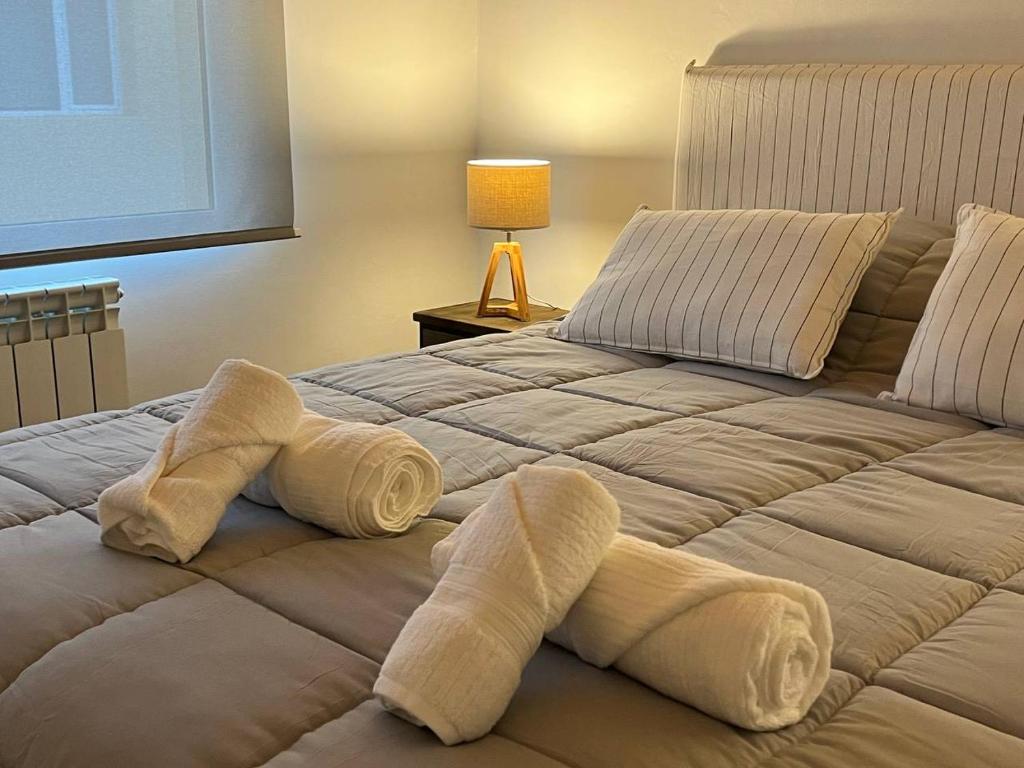 dois pares de toalhas numa cama num quarto em Moderno y tranquilo departamento em El Calafate