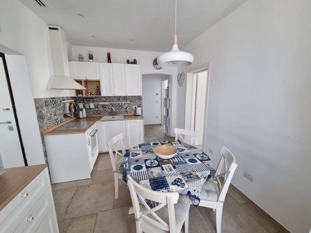 Una cocina y un comedor con mesa y sillas. en Dimora San Michele, en Giovinazzo