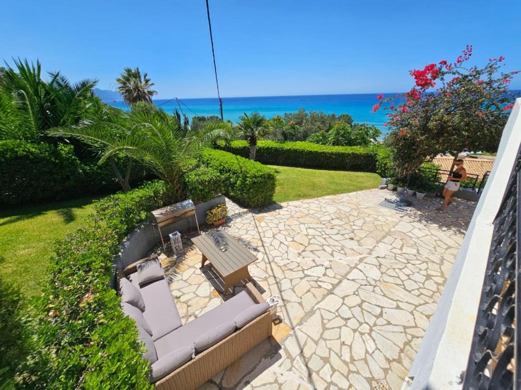 eine Terrasse mit einem Sofa, einem Tisch und Meerblick in der Unterkunft Corfu Glyfada Beach Apartment 45 in Glyfada