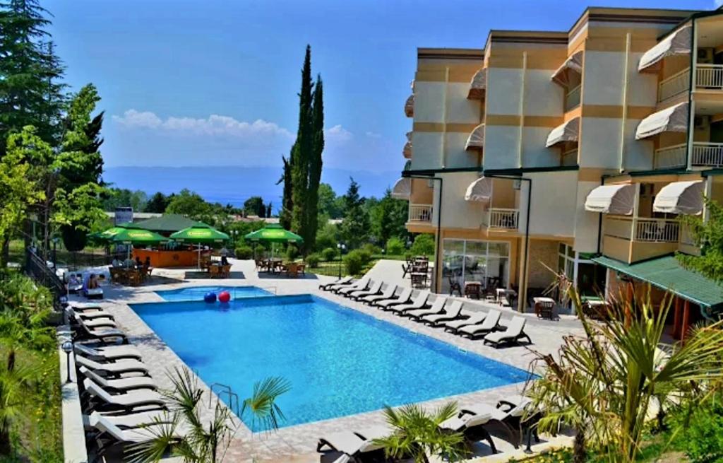 an image of a hotel with a pool and chairs at Hotel Bluebell in Ohrid