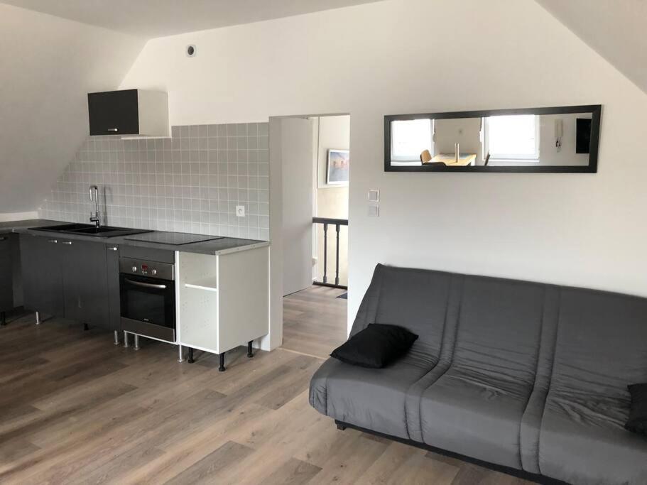 un salon avec un canapé noir et une cuisine dans l'établissement Appt de 40m2 proche de la plage, à Berck-sur-Mer