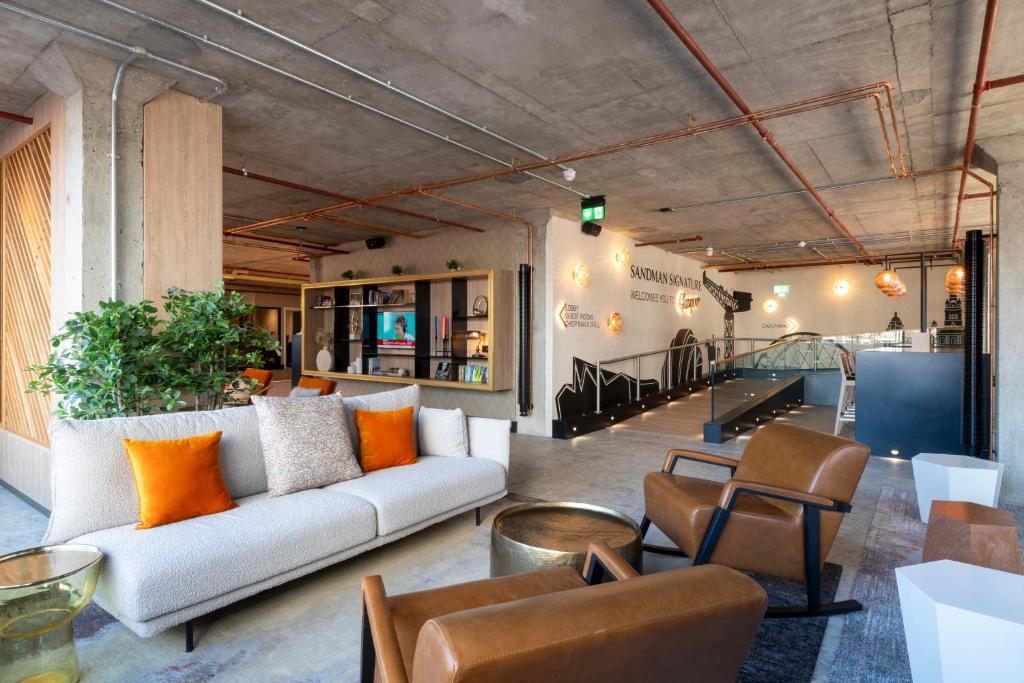 a living room with a couch and chairs at Sandman Signature Glasgow Hotel in Glasgow