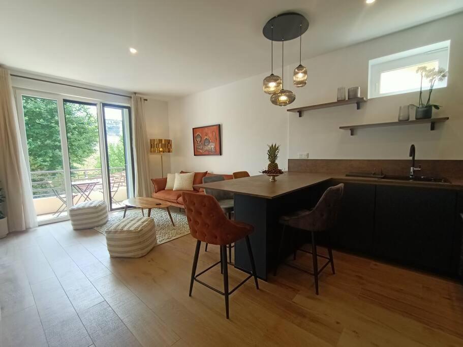 een keuken en een woonkamer met een tafel en stoelen bij The Chic Libération in Nice