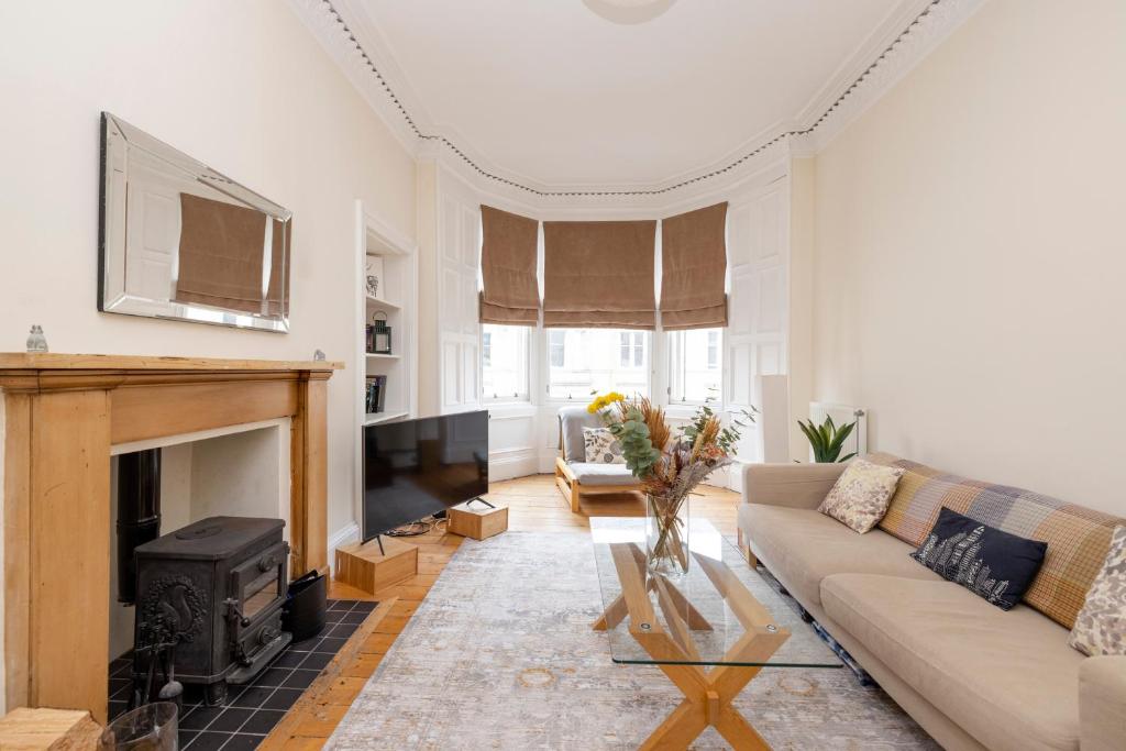a living room with a couch and a fireplace at Tasteful 1-bedroom Apartment near Edinburgh Meadows in Edinburgh