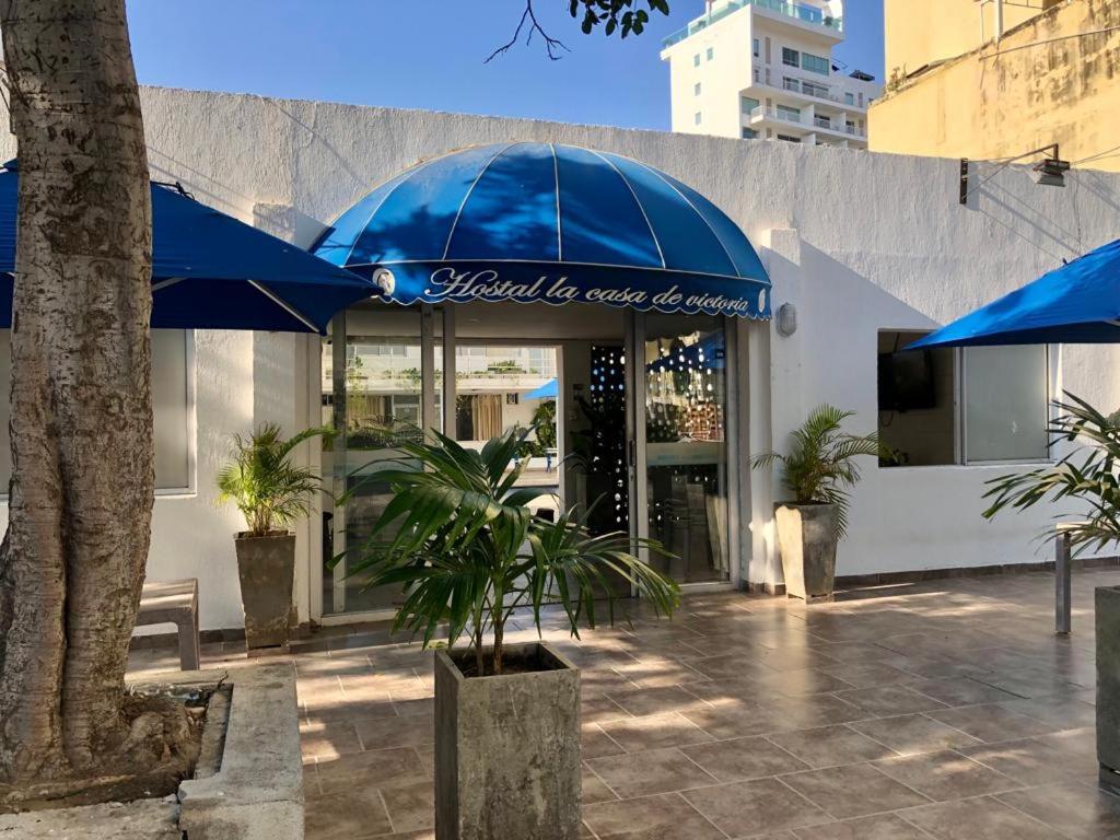 a building with a blue umbrella in front of it at Hotel Casa Victoria Rodadero Reservado in Gaira