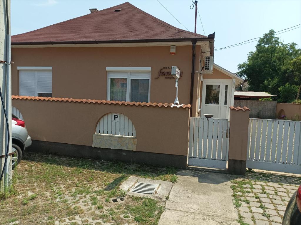 una casa con una valla blanca y una puerta en Family Vendégház, en Hajdúszoboszló