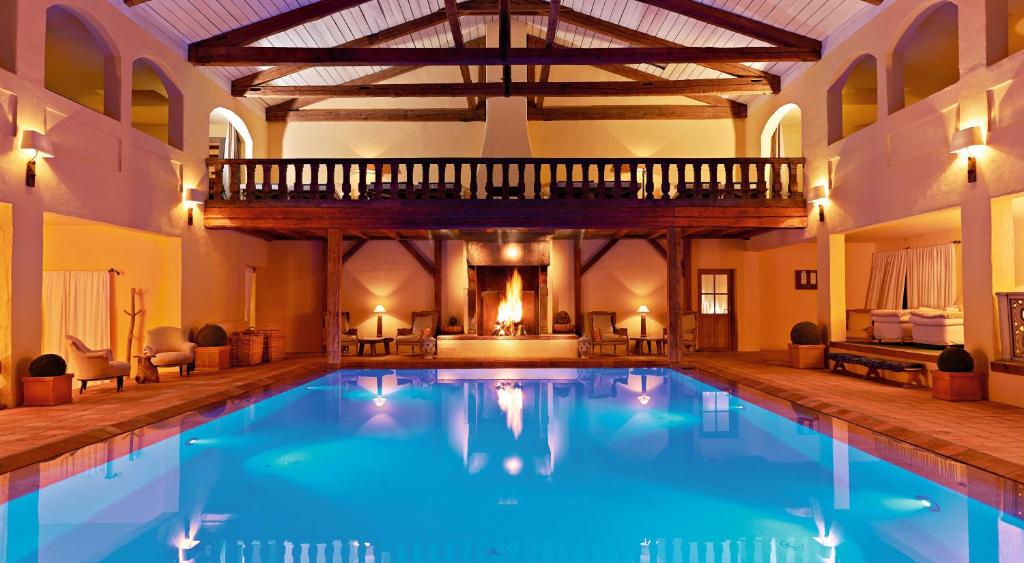 a large swimming pool in a building with a wooden ceiling at BLEICHE RESORT & SPA in Burg