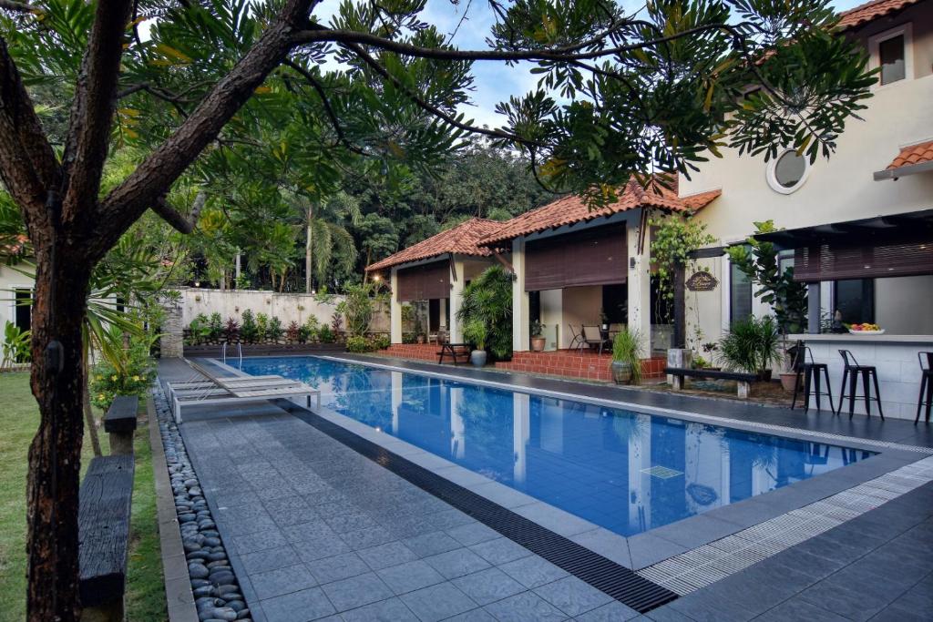 a swimming pool in front of a house at Elshape Holiday HOME in Malacca