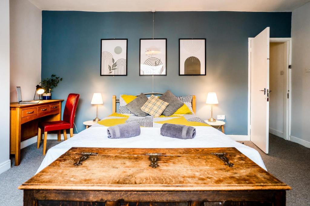 um quarto com uma cama grande e uma mesa de madeira em The Tigers Townhouse em Leicester