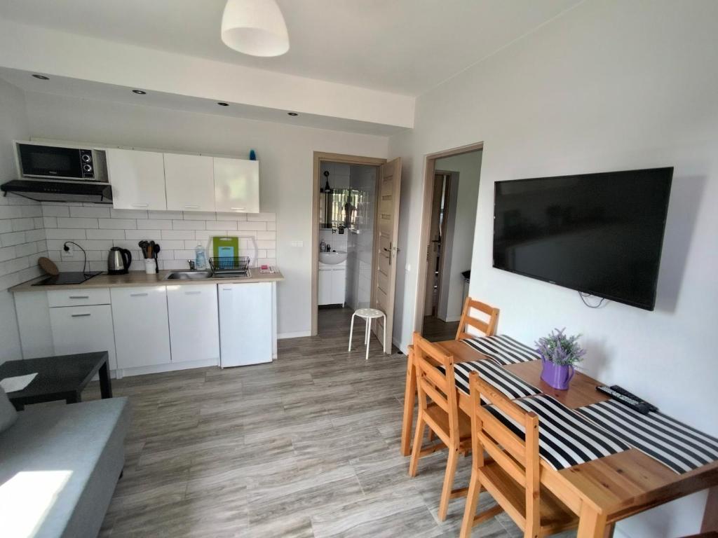 a kitchen and living room with a table and chairs at NASZE 4 KĄTY in Junoszyno