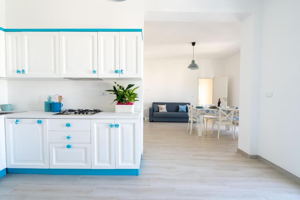 uma cozinha com armários brancos e uma sala de estar em Dimora le Dune a 100 MT dal mare em Campomarino