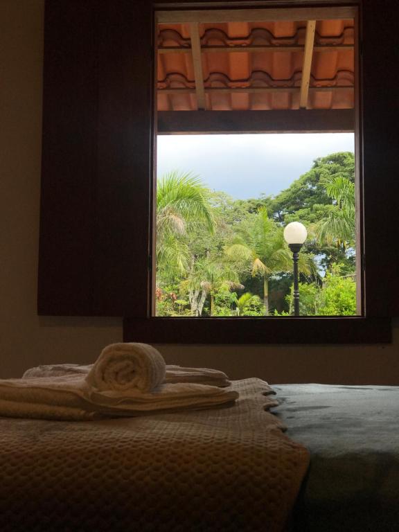 a window with a towel on a bed with a view at Chalés Jatobá in Prados