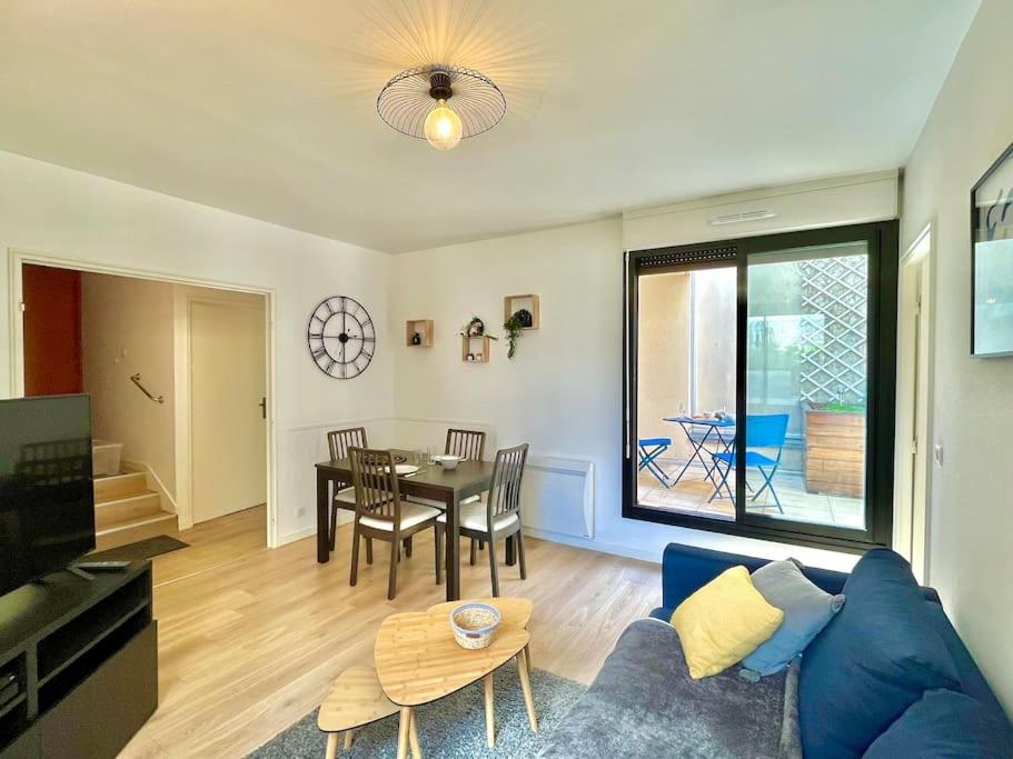 un salon avec un canapé bleu et une table dans l'établissement Le Nid d'Erlon - Reims, à Reims