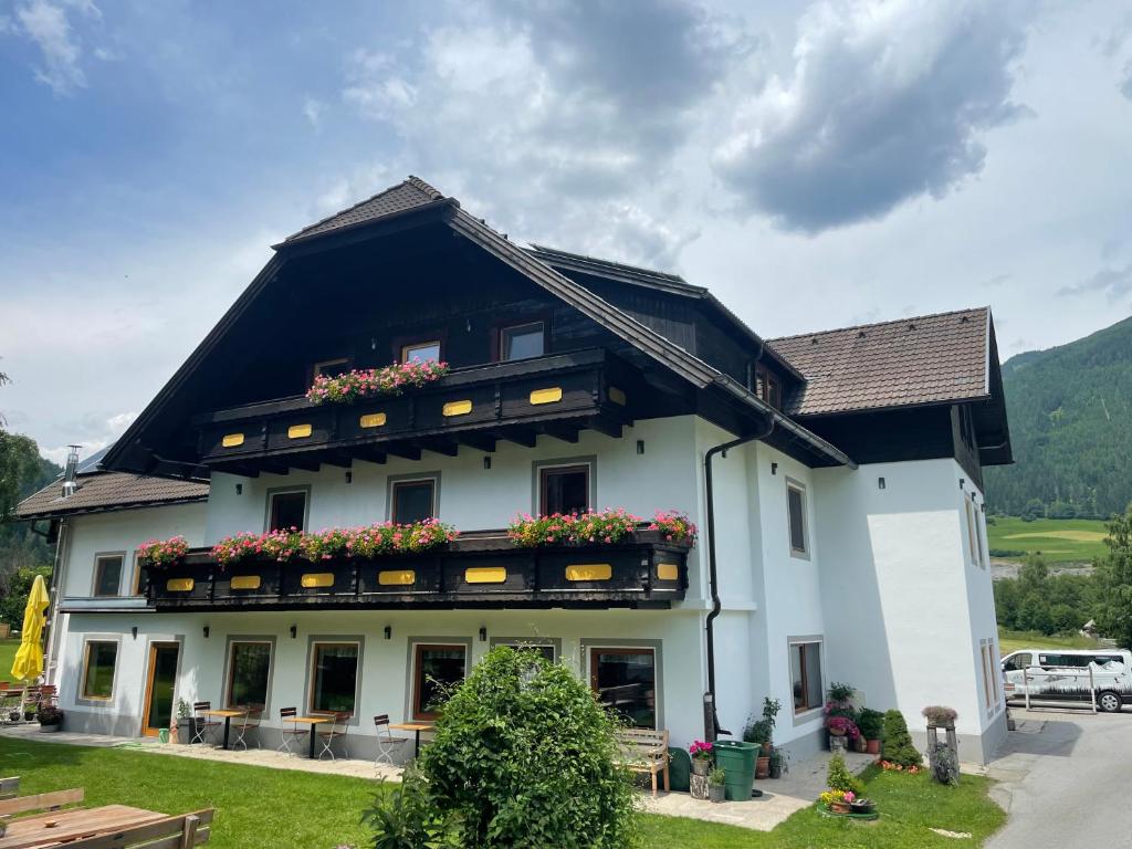 ein großes weißes Gebäude mit Blumen darauf in der Unterkunft Landhaus Lungau in Sankt Michael im Lungau