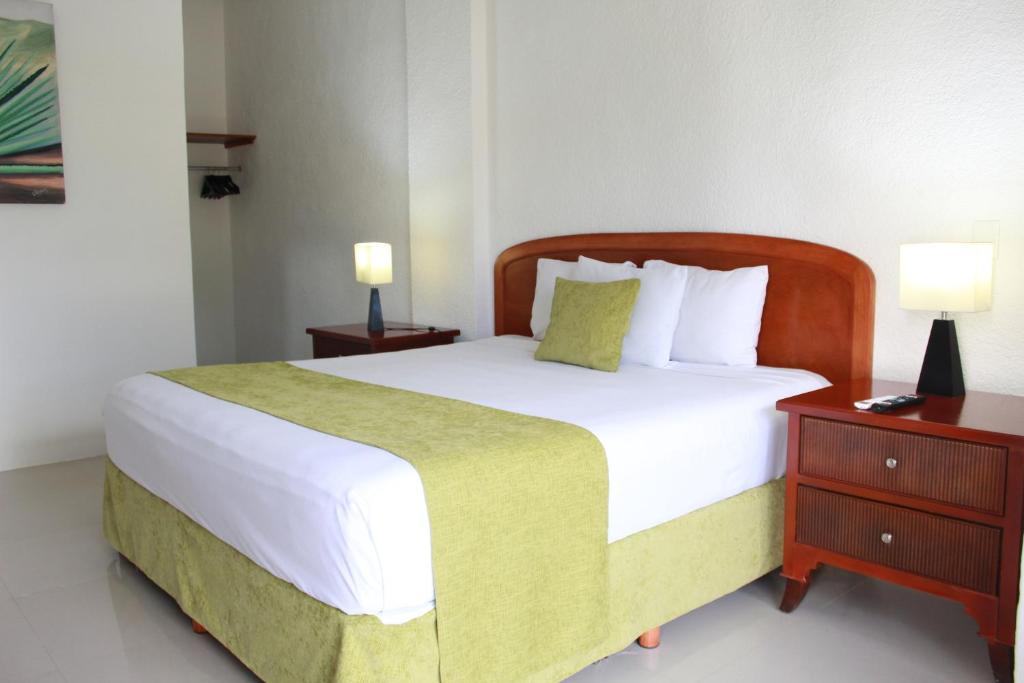 a bedroom with a large bed and two night stands at Sunlight Hotel in Cancún