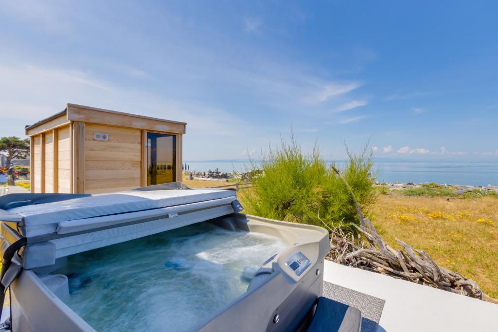 a hot tub on top of a building with the ocean in the background at Point Roberts Cottage with Ocean Views and Hot Tub! in Point Roberts