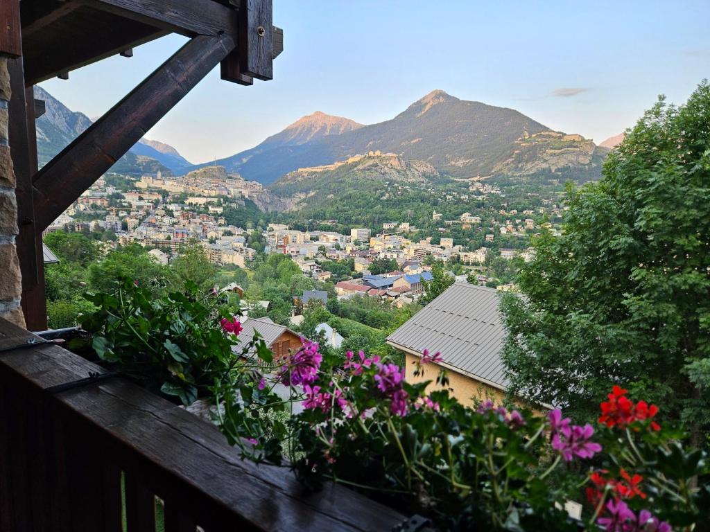 vue d'une ville avec des fleurs sur un balcon dans l'établissement Chalet Puy-Saint-Pierre avec vue, à Puy-Saint-Pierre