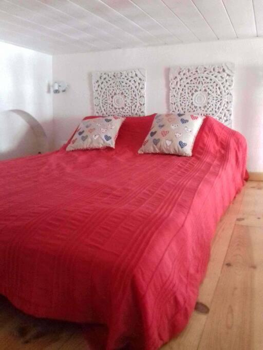 a bedroom with a red bed with pillows on it at Bel appt 3 * plein Centre ville 4 pers. + balcon in Cauterets