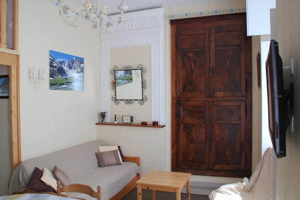 a living room with a couch and a wooden door at Bel appt 3 * plein Centre ville 4 pers. + balcon in Cauterets
