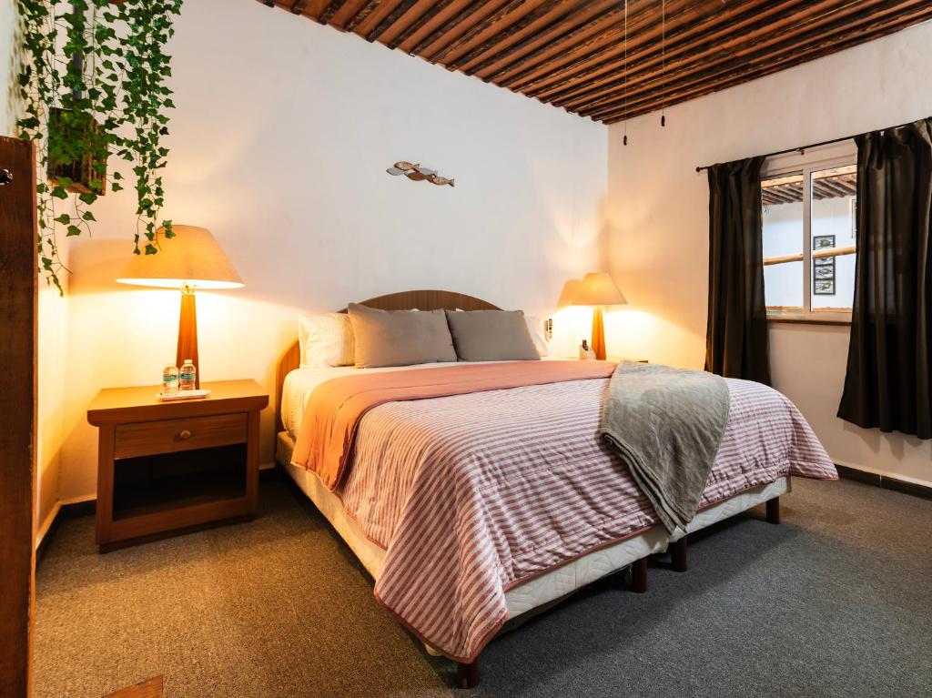 a bedroom with a bed and two lamps and a window at OYO Posada Del Pescador in Cabo San Lucas