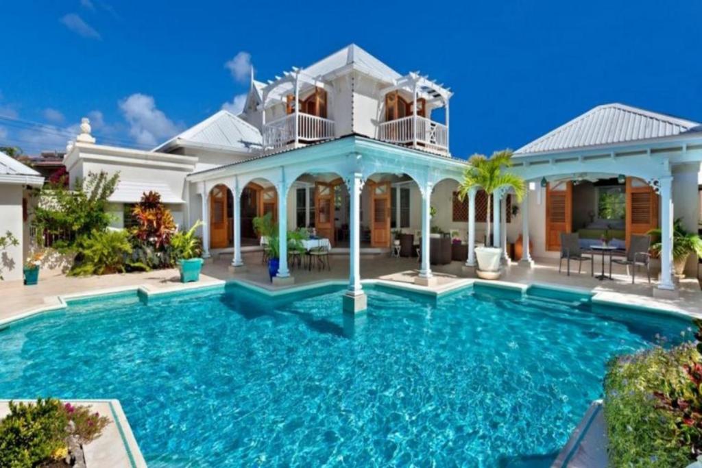 a house with a swimming pool in front of it at Rock Ridge by Barbados Sothebys International Realty in Saint Peter