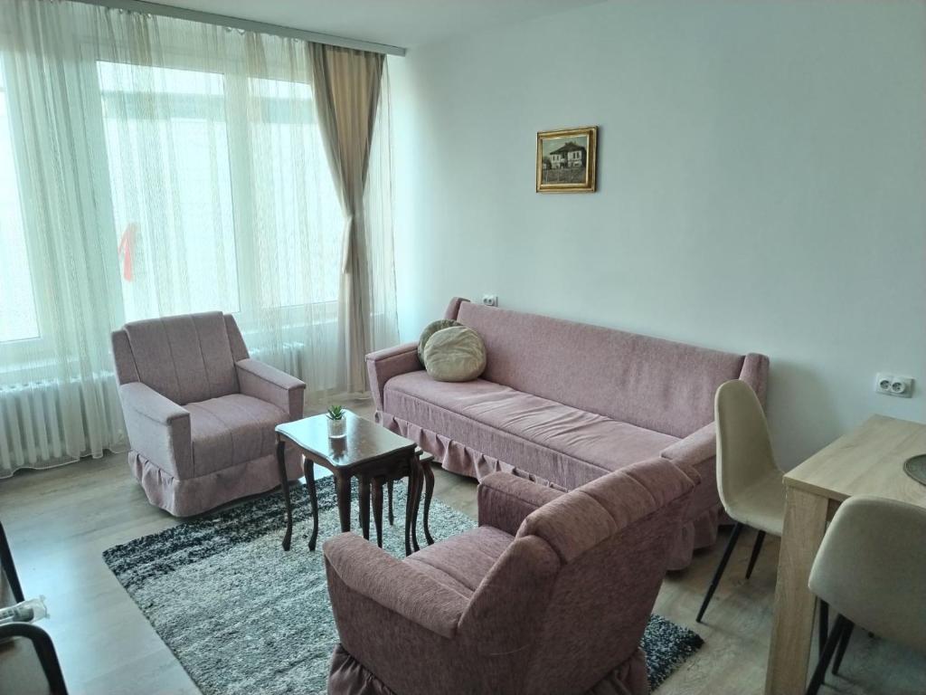 ein Wohnzimmer mit einem Sofa und einem Stuhl in der Unterkunft Epicentar Nis in Niš