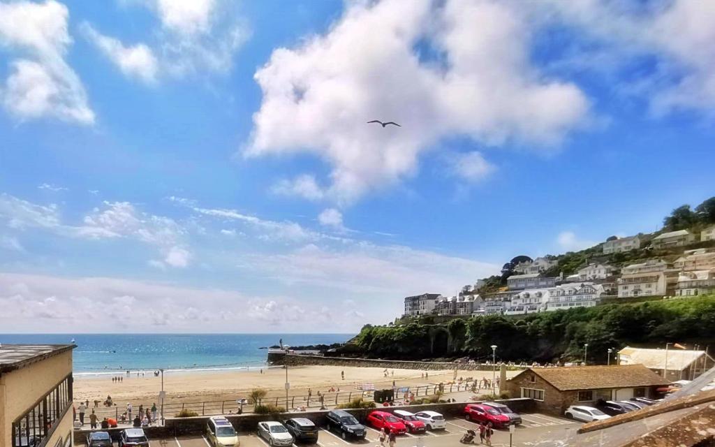 a bird flying in the sky over a beach at The Decker Apartment in Looe