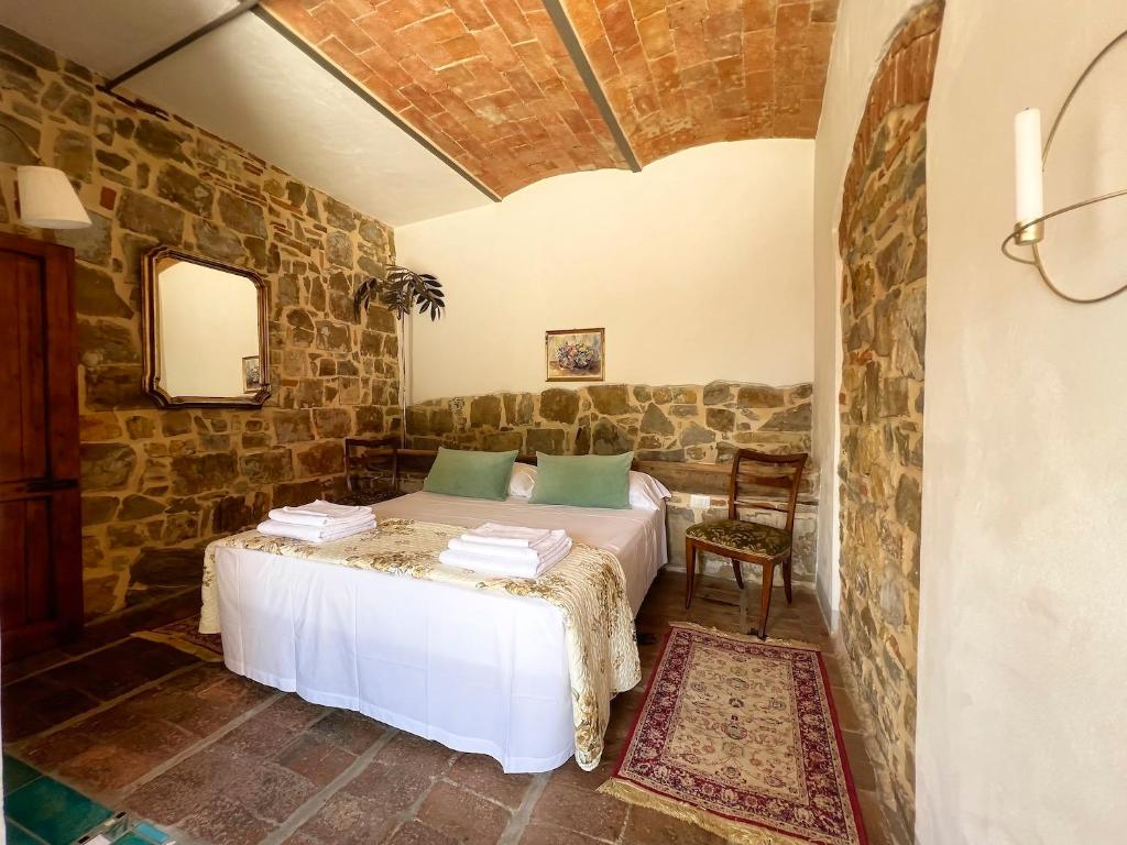 1 dormitorio con 1 cama y 1 silla en una habitación en Podere Belvedere Tuscany, en Pontassieve