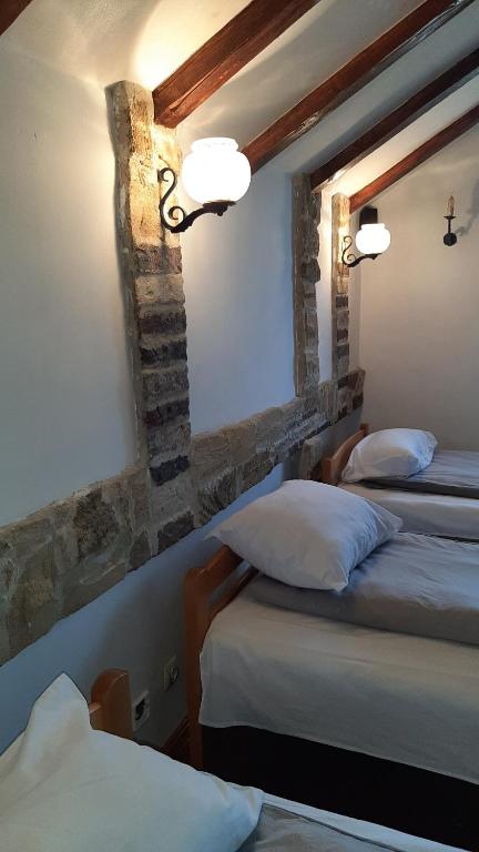 a bedroom with two beds and two lights on the wall at Apartman Kamen 1 in Negotin
