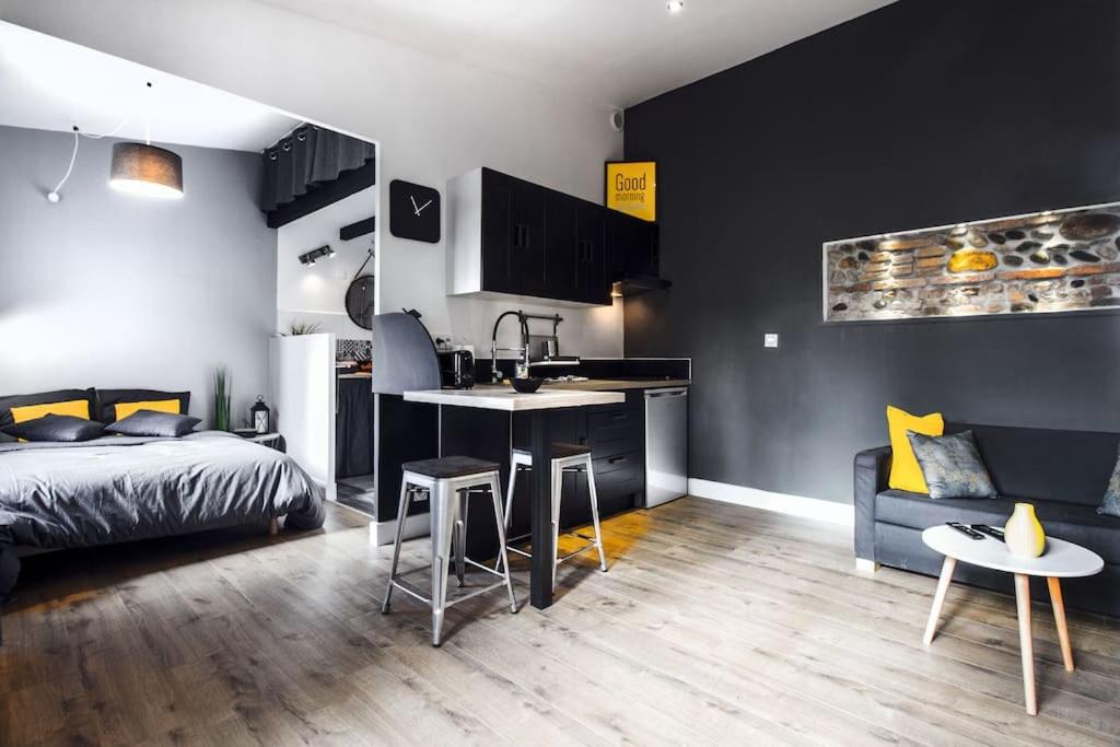sypialnia z łóżkiem i biurkiem oraz kuchnia w obiekcie Coeur Toulouse St Cyprien T1 bis type Loft w Tuluzie