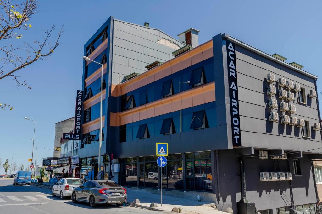een gebouw in een straat waar auto's voor geparkeerd staan bij ACAR AIRPORT +PLUS in Arnavutköy