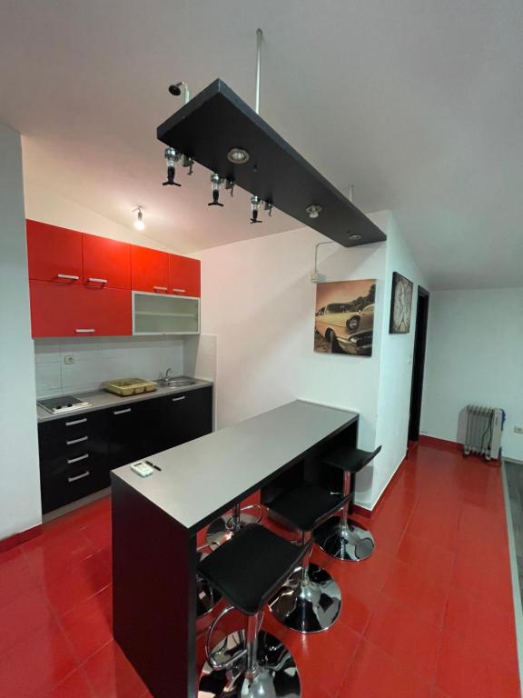 cocina con encimera negra y suelo rojo en MORIC APARTMENTS 2, en Stankovci