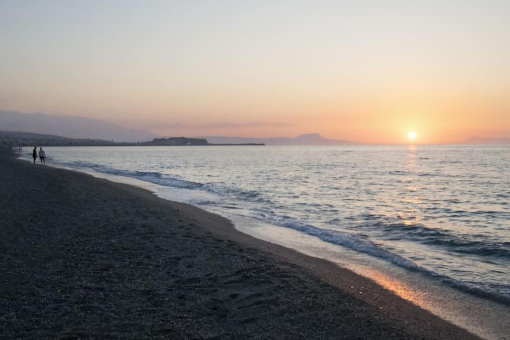 two people walking on the beach at sunset at Nick and Helen 3 in Perivólia