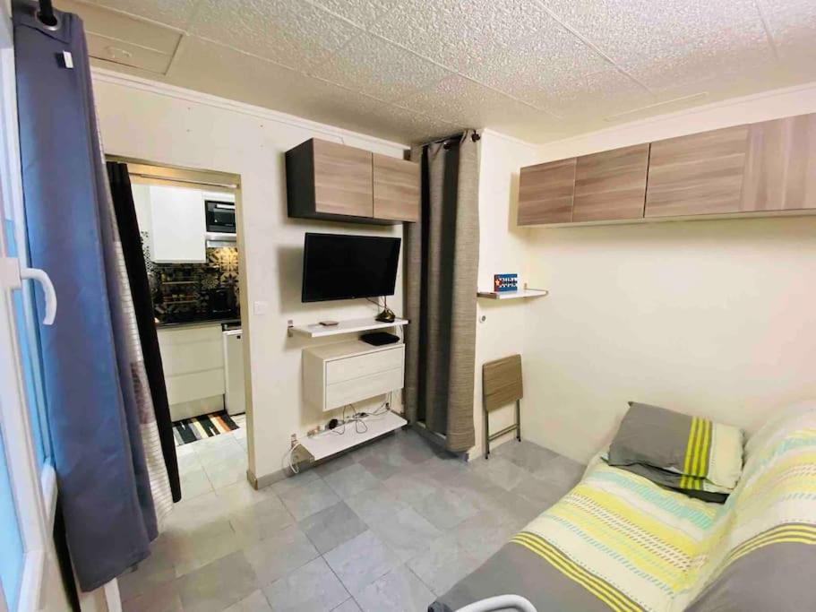 une chambre avec un lit et une télévision dans l'établissement Studio - Butte aux cailles 13eme, à Paris