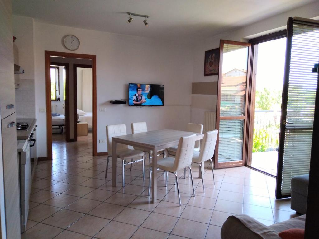 cocina y comedor con mesa y sillas en Flat Garda, en Cavalcaselle