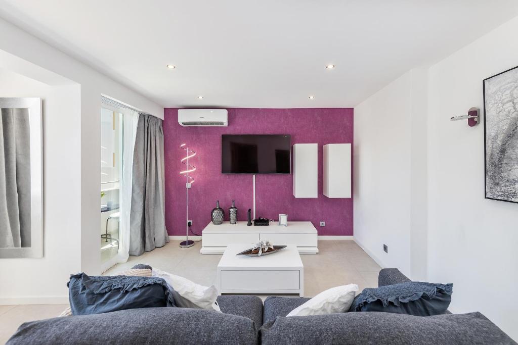 uma sala de estar com um sofá e uma TV em Coração do Mar by OCvillas em Albufeira