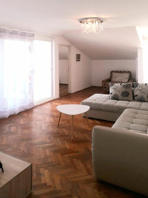 ein Wohnzimmer mit einem Sofa und einem Tisch in der Unterkunft Elizabeth apartment 2 bedroom sityBudva in Budva