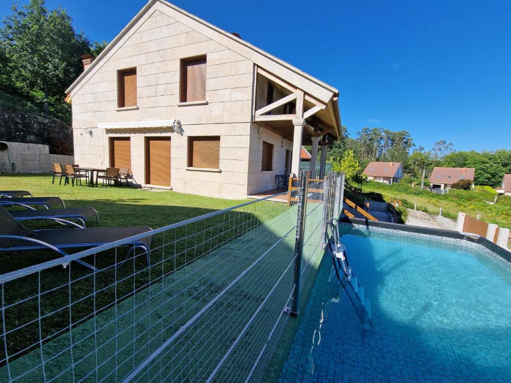 una casa y una piscina frente a una casa en Casa Baixo O Castelo, en Puente Caldelas