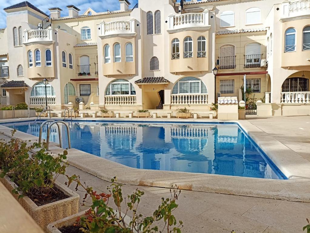 a swimming pool in front of a building at Duquesa Beach in Torrevieja